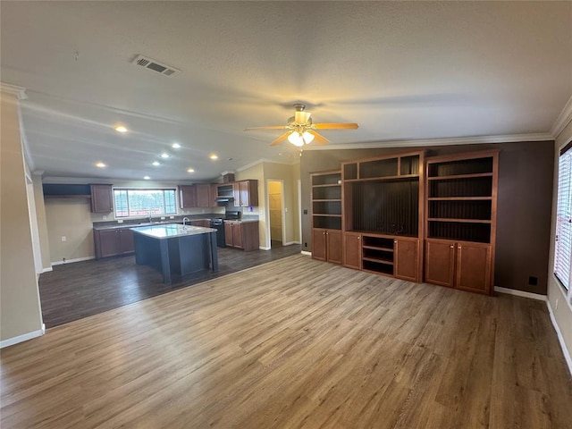 kitchen with a center island, lofted ceiling, dark wood-type flooring, crown molding, and ceiling fan