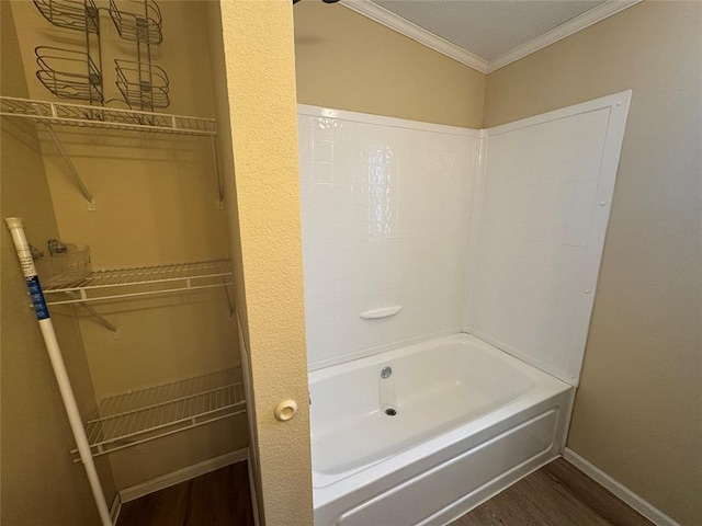 bathroom with hardwood / wood-style floors, tub / shower combination, and ornamental molding