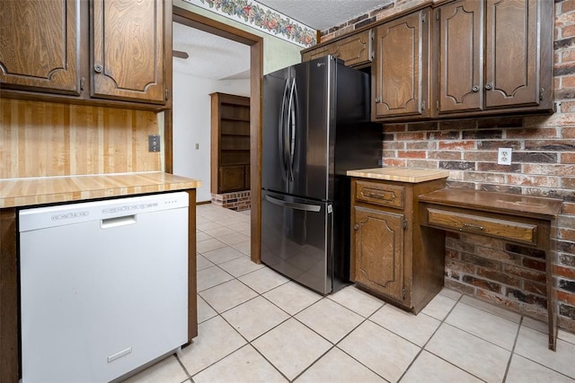 kitchen featuring a textured ceiling, stainless steel refrigerator, white dishwasher, and light tile patterned floors