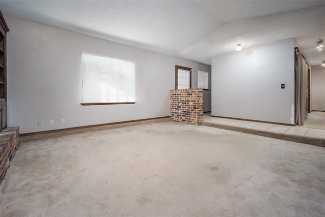 unfurnished living room featuring light carpet and vaulted ceiling