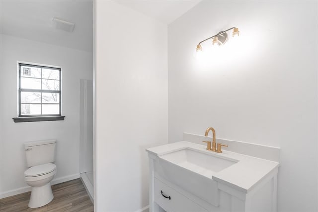 bathroom with hardwood / wood-style flooring, vanity, and toilet