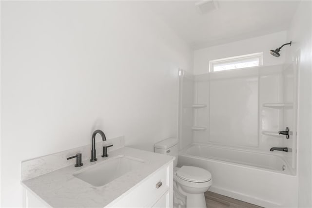 full bathroom with toilet, hardwood / wood-style floors, vanity, and tub / shower combination