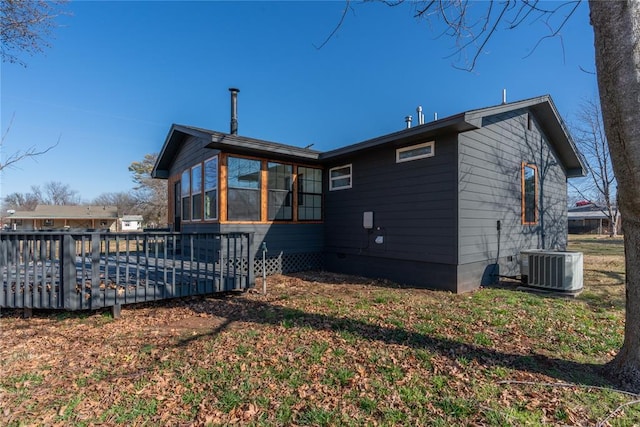 rear view of property featuring a sunroom, a deck, and central air condition unit