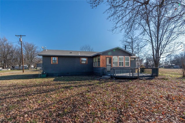 rear view of property featuring a yard and a wooden deck