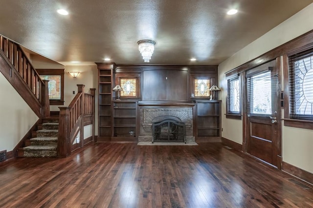 unfurnished living room with dark wood-type flooring and a brick fireplace