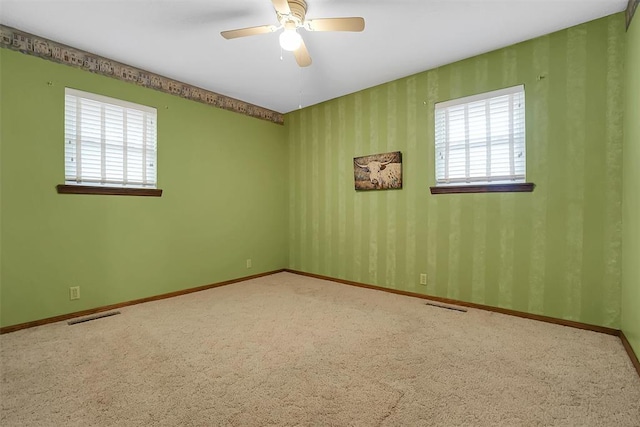 empty room with ceiling fan and carpet