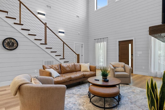 living room featuring a towering ceiling and hardwood / wood-style flooring