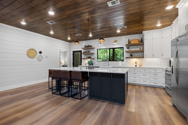 kitchen with light hardwood / wood-style flooring, white cabinets, and stainless steel appliances