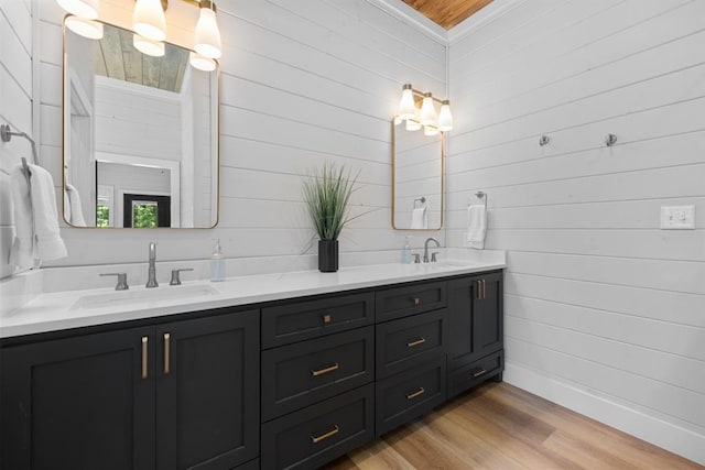 bathroom with wood-type flooring, vanity, and wooden walls