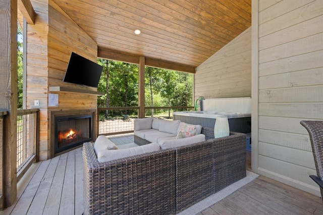 deck with an outdoor living space with a fireplace