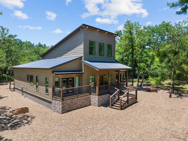 back of house featuring metal roof, a porch, and french doors