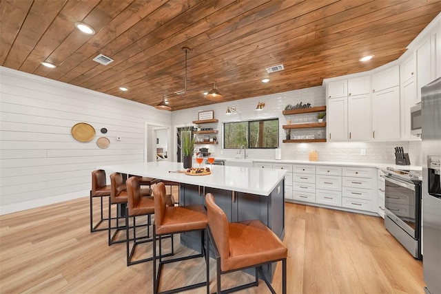 kitchen with wooden ceiling, open shelves, light wood-type flooring, light countertops, and appliances with stainless steel finishes