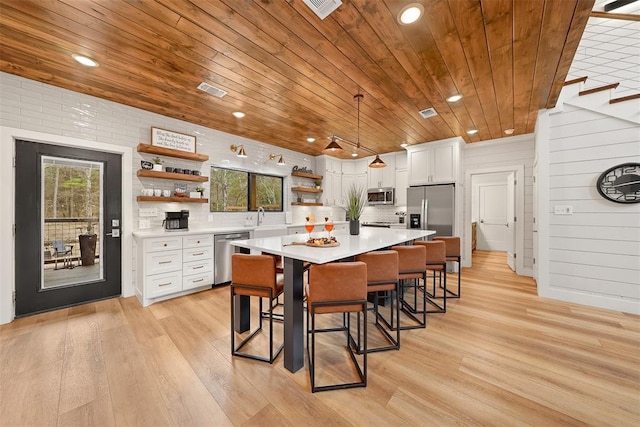 kitchen with wooden ceiling, open shelves, appliances with stainless steel finishes, white cabinets, and a sink