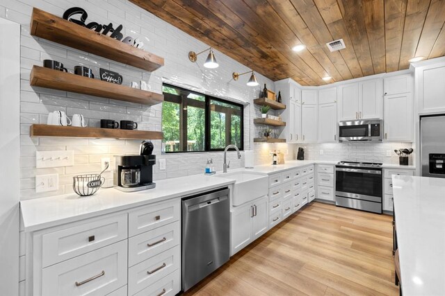 kitchen featuring wooden ceiling, open shelves, visible vents, light countertops, and appliances with stainless steel finishes