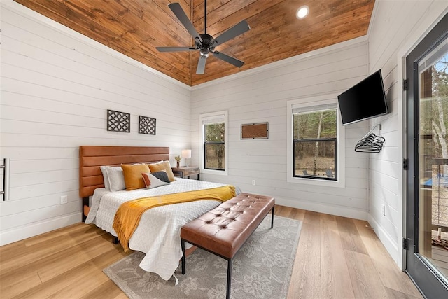 bedroom with wooden ceiling, baseboards, wood walls, and light wood-style floors