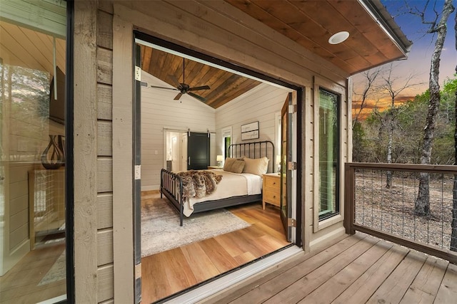 bedroom featuring wooden walls, lofted ceiling, wood-type flooring, and wood ceiling