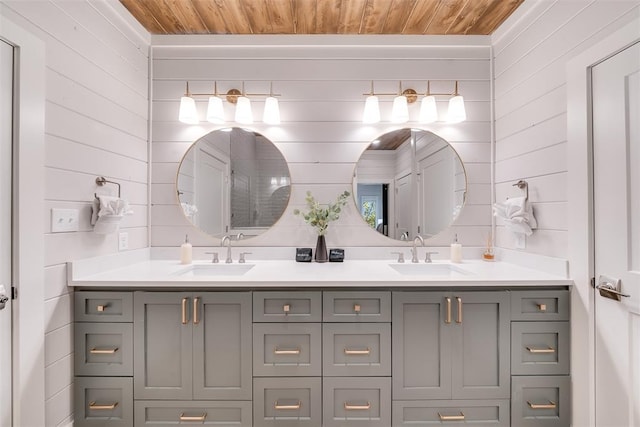 bathroom featuring wood ceiling, wood walls, and a sink