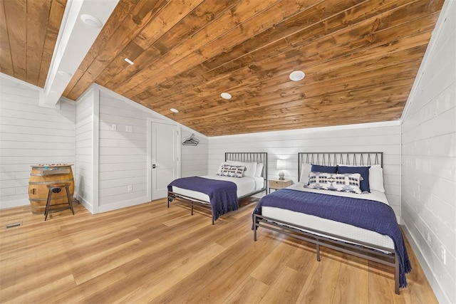 bedroom with vaulted ceiling, wooden walls, light wood-style flooring, and wood ceiling