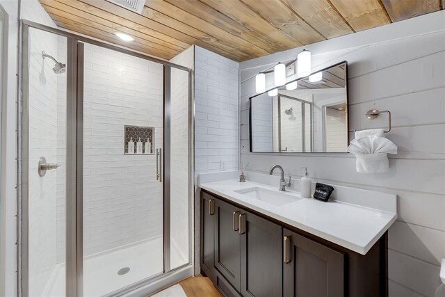 bathroom with wood ceiling, vanity, and a shower stall