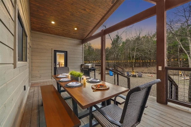 deck featuring outdoor dining area and a grill