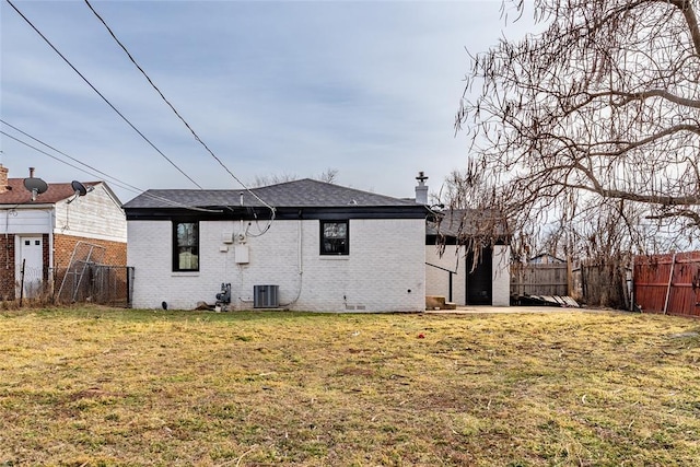 back of house featuring central AC unit and a lawn