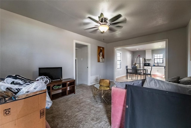 carpeted bedroom featuring stainless steel fridge and ceiling fan