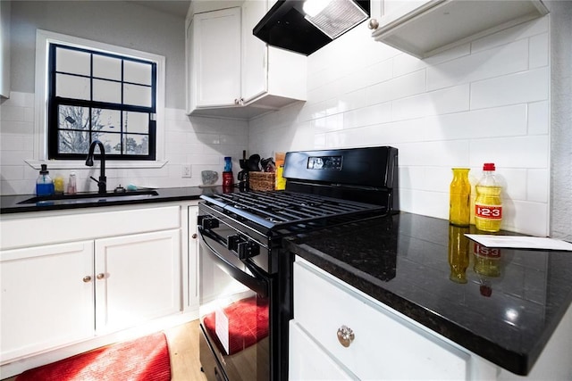 kitchen with sink, black gas range, backsplash, ventilation hood, and white cabinets