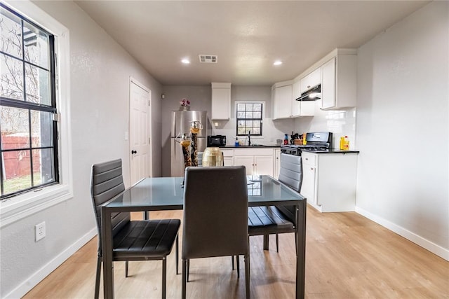 dining area with sink and light wood-type flooring