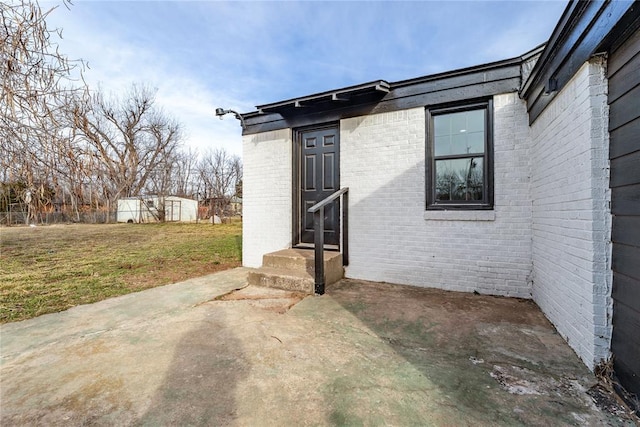 entrance to property with a yard and a patio