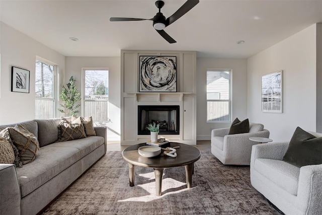 living room featuring ceiling fan, a fireplace, and hardwood / wood-style floors