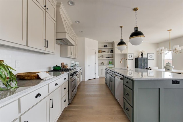 kitchen featuring appliances with stainless steel finishes, a kitchen island with sink, gray cabinetry, and pendant lighting