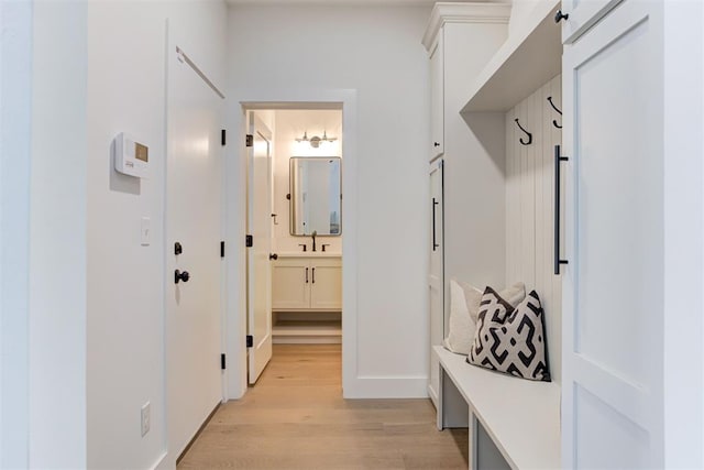 mudroom with sink and light hardwood / wood-style flooring