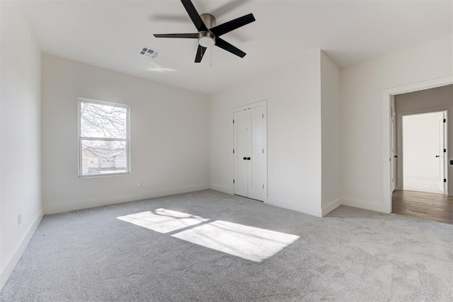 unfurnished bedroom with ceiling fan, light colored carpet, and a closet