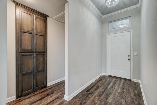 foyer featuring a chandelier, ornamental molding, and dark wood-type flooring