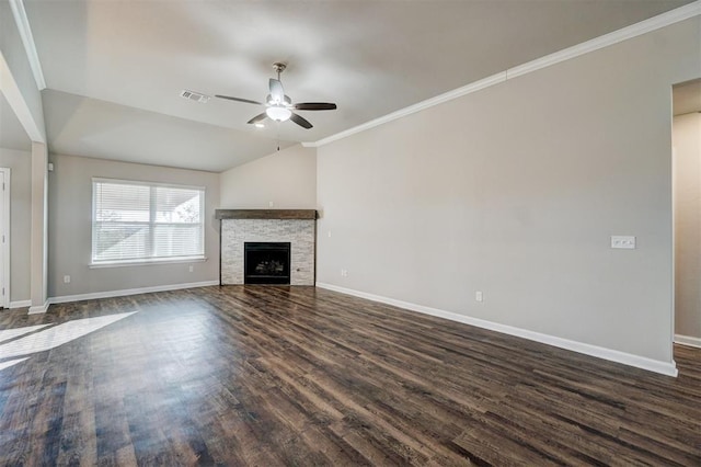 unfurnished living room featuring ceiling fan, a stone fireplace, dark hardwood / wood-style floors, vaulted ceiling, and ornamental molding