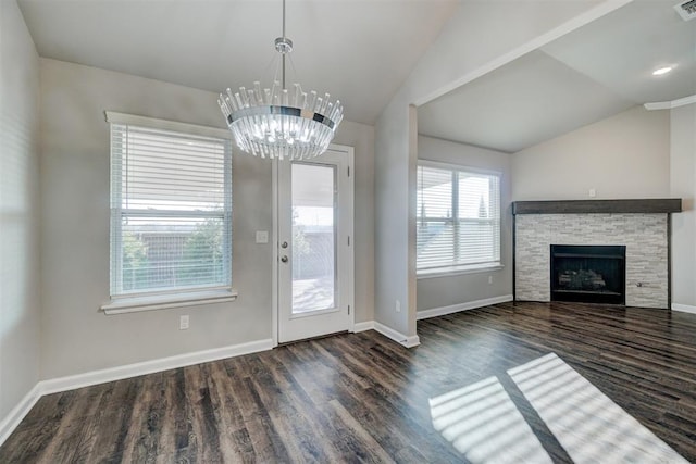 doorway with a stone fireplace, lofted ceiling, dark hardwood / wood-style floors, and a notable chandelier