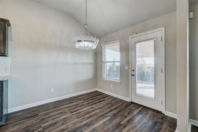 unfurnished dining area with dark hardwood / wood-style floors, an inviting chandelier, and vaulted ceiling