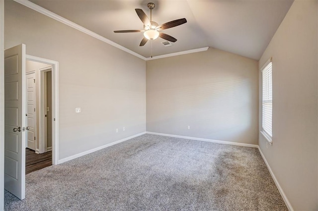 carpeted empty room featuring ceiling fan, crown molding, and vaulted ceiling