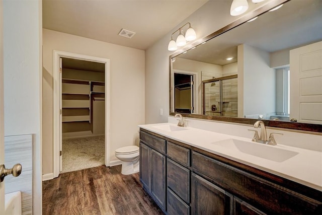 bathroom with vanity, hardwood / wood-style flooring, toilet, and walk in shower