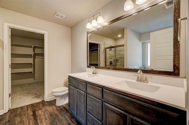 bathroom with vanity, toilet, wood-type flooring, and walk in shower