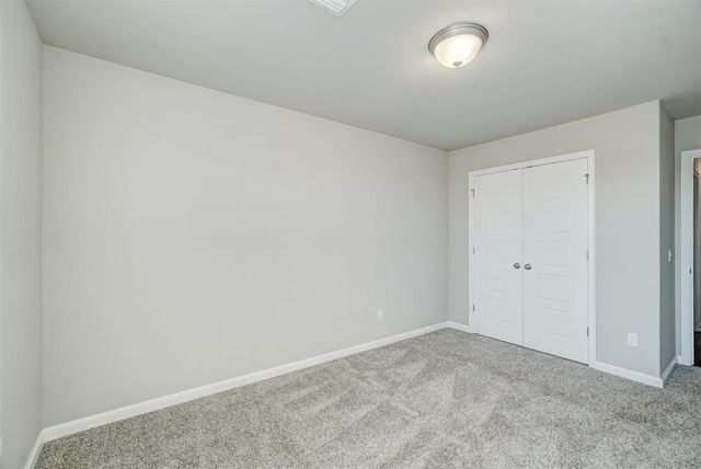 unfurnished bedroom with light colored carpet and a closet