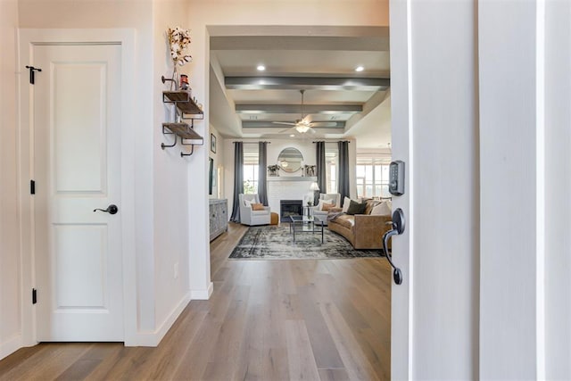 foyer with beam ceiling, ceiling fan, and light wood-type flooring