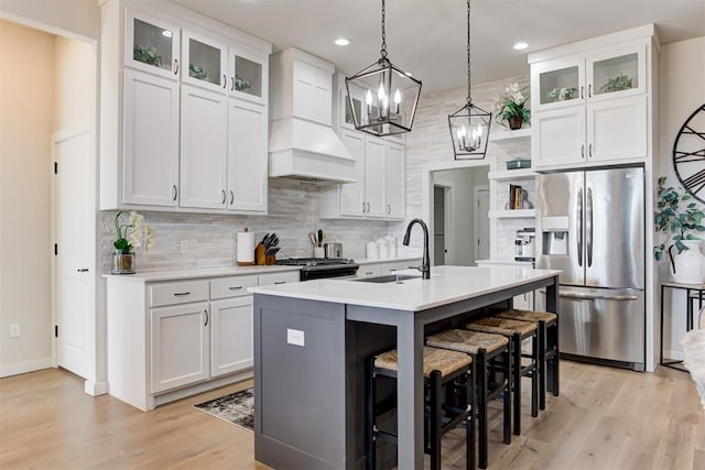 kitchen featuring white cabinets, custom range hood, and appliances with stainless steel finishes