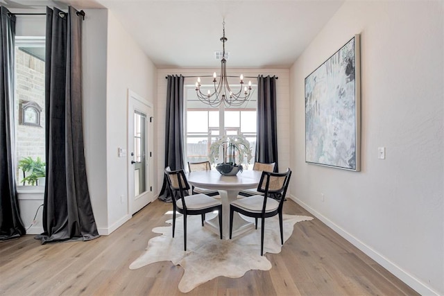 dining room featuring a notable chandelier and light wood-type flooring