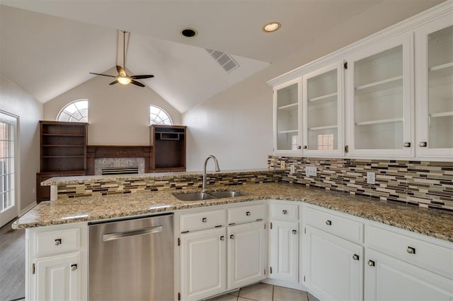 kitchen with vaulted ceiling, tasteful backsplash, white cabinetry, dishwasher, and sink