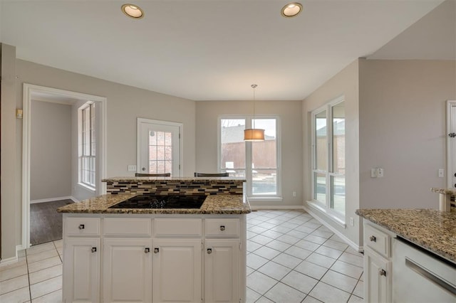 kitchen featuring white cabinetry, a center island, black electric cooktop, stone counters, and pendant lighting