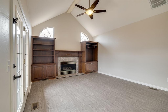 unfurnished living room featuring ceiling fan, wood-type flooring, beam ceiling, and high vaulted ceiling