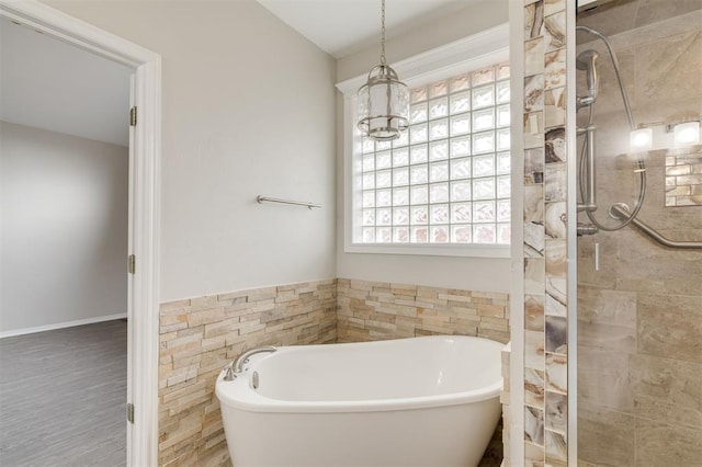 bathroom with shower with separate bathtub and a chandelier