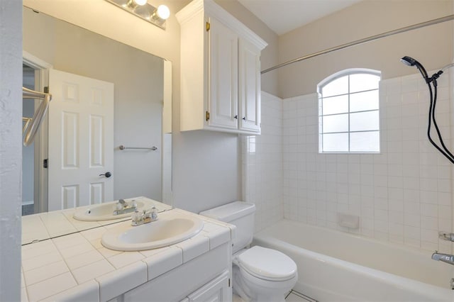 full bathroom with vanity, tiled shower / bath combo, and toilet