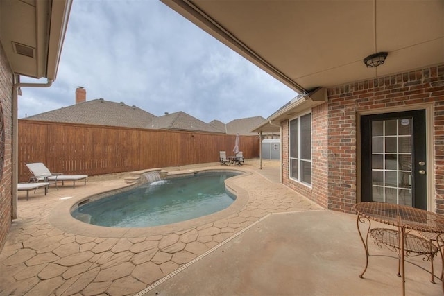 view of swimming pool with pool water feature and a patio area